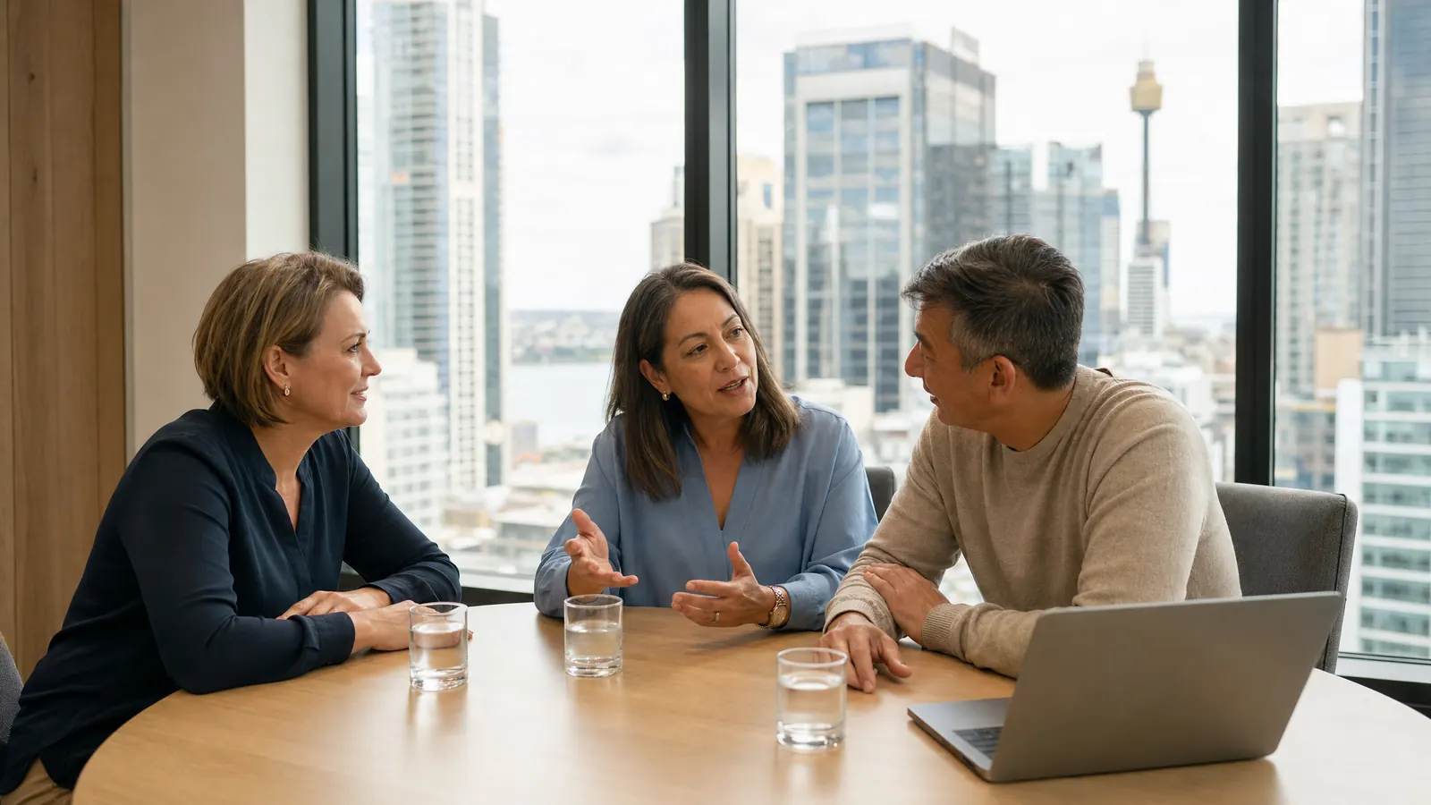 Three advisers talk through a client case above the Sydney skyline