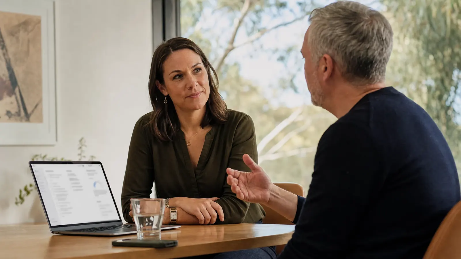 An adviser listens to a client across a table