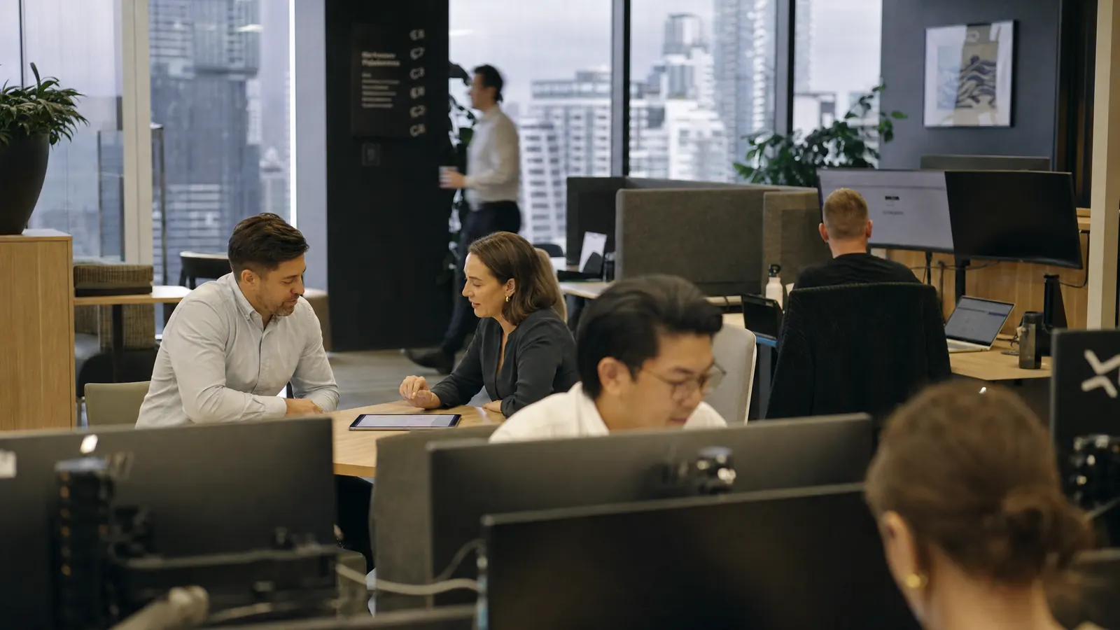 Advisers and support staff at work across a busy office floor